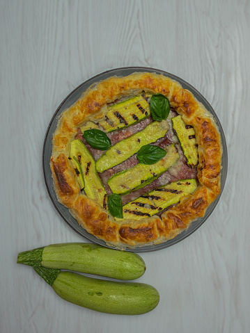 savory pie with courgettes and basil on a round plate