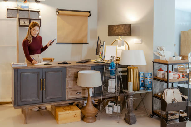 istock Female Entrepreneur Writes in a Notebook in Home Decor Store 1698296423