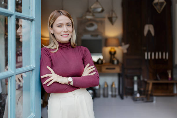 Portrait of a happy Latin American saleswoman working at a men's clothing store and looking at the camera smiling