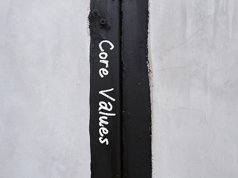 Black paint in the middle of cement wall with text written CORE VALUES, means set of fundamental beliefs, ideals or practices which is direction of how to conduct life or career