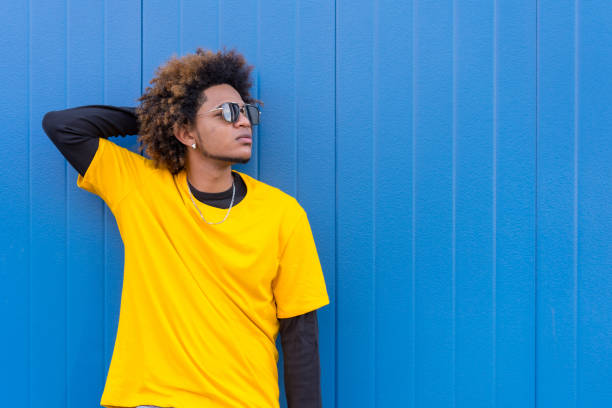 istock Street style brunette man posing relaxed leaning on a wall 1698313236