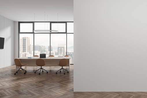 Business office room interior with meeting table and armchairs, hardwood floor. Conference space with laptop and tv screen, panoramic window on Kuala Lumpur skyscrapers. 3D rendering