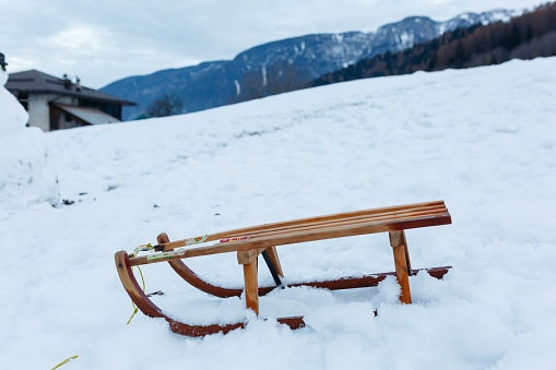 view of wooden sled in front against snow mountain background