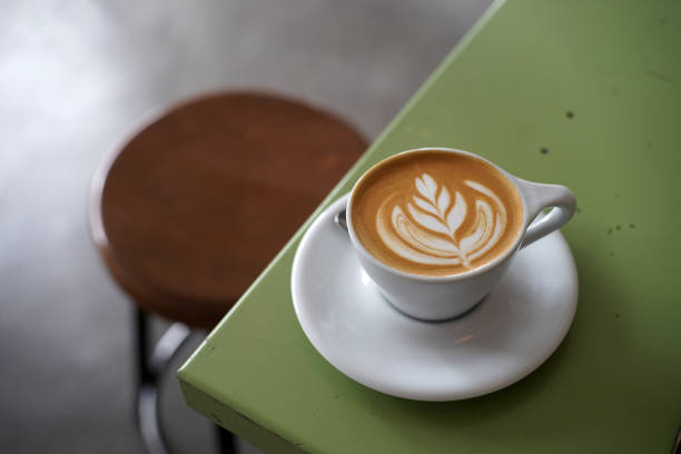 istock Hot fresh latte coffee on green table background 1698352581