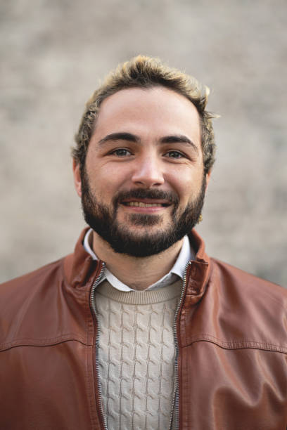 istock Bearded young man smiling outdoors in the city 1698353121