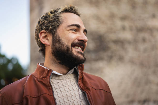 istock Bearded young man smiling outdoors in the city 1698354160