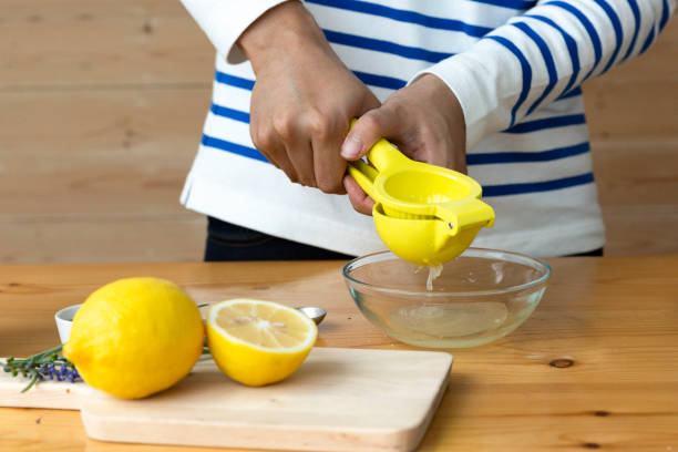 istock Hands squeezing lemon juice to glass bowl 1698356328