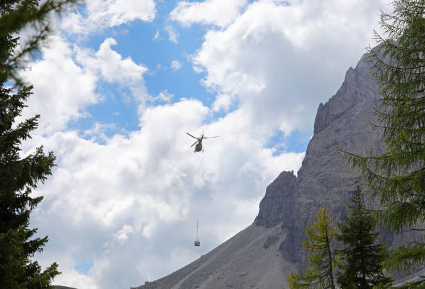 istock Transport helicopter with a heavy load hanging under flight in the mountains 1698369793