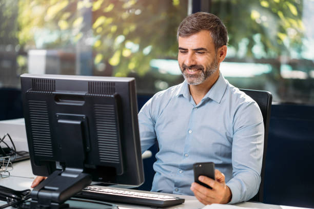 istock Business man sitting in desk using smartphone and computer 1698386952