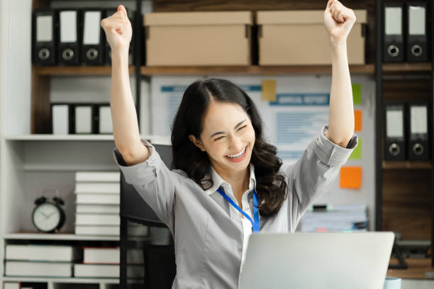 istock Overjoyed charming excited asian business woman worker using laptop working in office, feeling happy. 1698422938