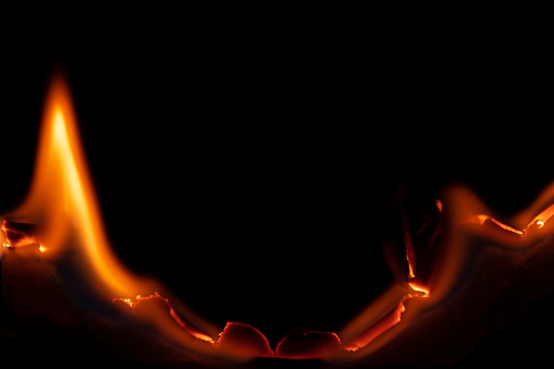 burning paper, glowing edge of paper on a black background