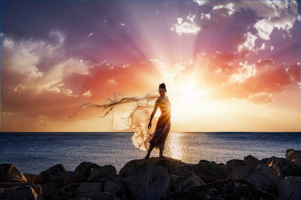 Ballerina dancing with thin nylon on the rocks.