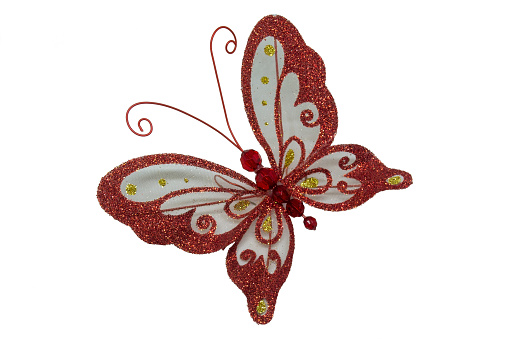The set is a red butterfly on a white background. Toy on the New Year tree in the form of a butterfly. Decoration decoration red butterfly directed to the upper left corner. Decoration for the New Year tree