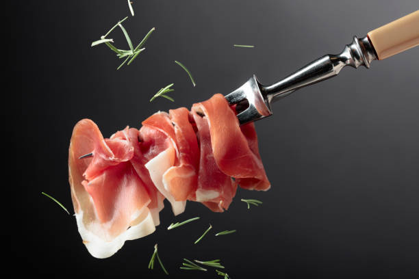 istock Slices of prosciutto on a fork. 1698496270