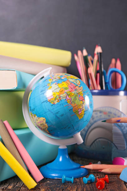 istock Back to school concept- book, globe  and pencils on blackboard 1698519997