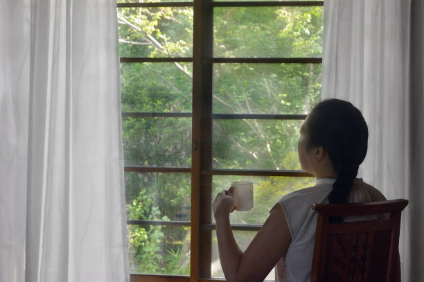 Woman Having a Cup of Coffee by the Window/Studio Shot