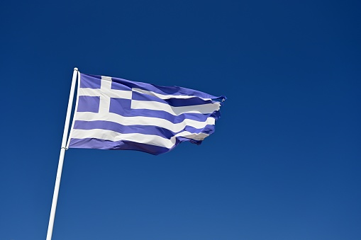 The flag of Greece. Flying in the wind against the blue sky. Corfu Island - Greece. Concept for summer holidays and vacation.