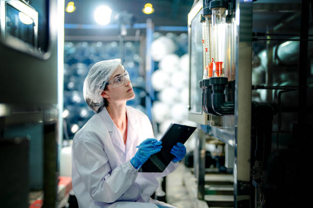istock scientist worker checking the quality of Reverse osmosis machine system at the industrial factory. Female worker recording data at the control panel with measure pressure for recycle portable plant. 1698592772