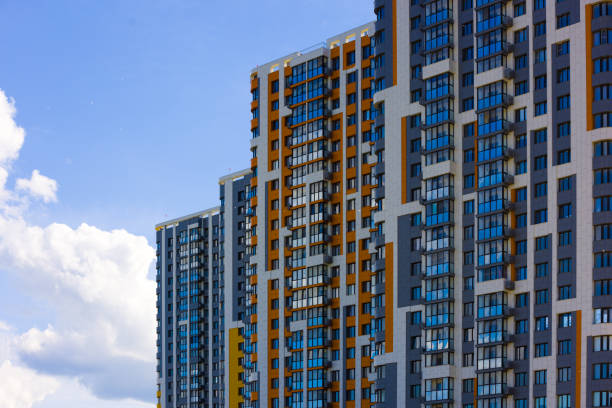 istock freshly built high rise apartment buildings on blue sky background with white clouds 1698598285