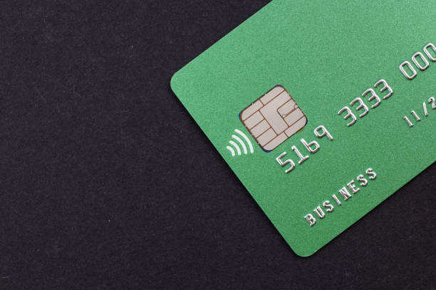 Green credit card on dark background.