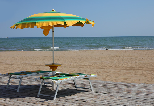 yellow and green sunshade and deckchair in the beach in summer