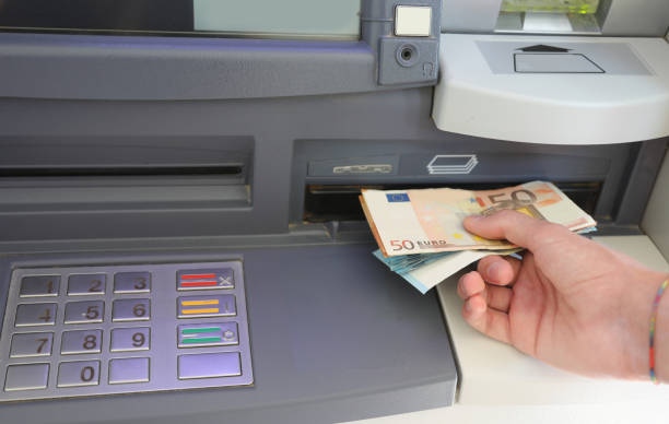istock withdrawing euro banknotes in automatic teller machine in Europe 1698619451