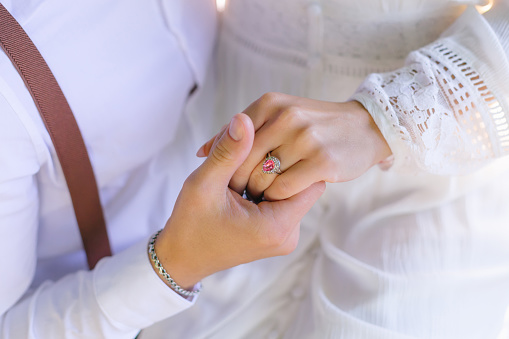 a couple in love in festive clothes hold hands. close up. beautiful ring on the girl's finger