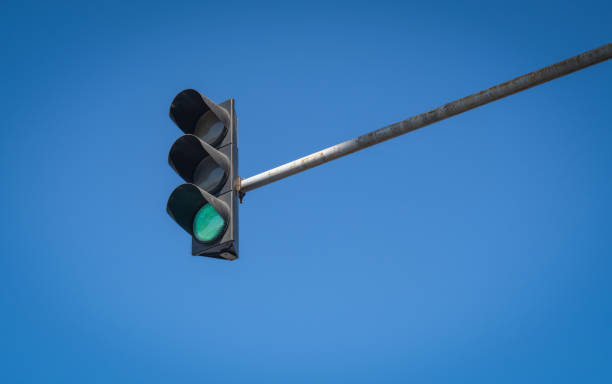 istock green Traffic Light. blue sky in Background. hanging above. 1698621253