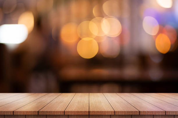 istock Empty wooden table top with lights bokeh on blur restaurant background. 1698622411