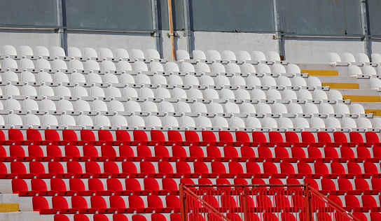 white and red seats in the stands of the stadium without people before the event