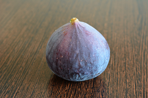 purple fig isolated on the dark wooden background close up