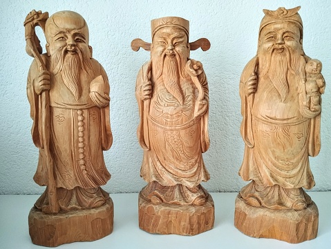 These handmade wooden statues of Thuja are a Trio of Daoist Stellar Gods representing Longevity, Wealth and Good fortune. They are also known by the names Siew Lok and Hok. The display of this trio is common in South East Asia, in residential as well as commercial settings. I bought this trio in Vietnam and I have displayed them ever since in my home
