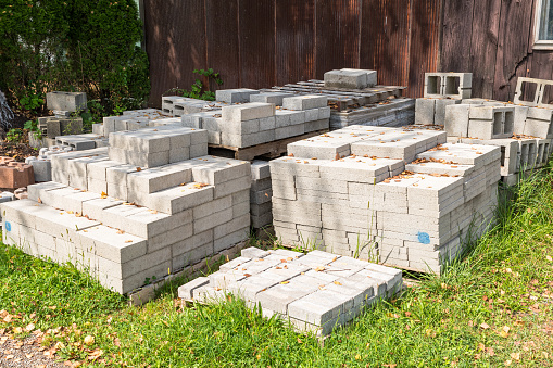 Bricks, stone and concrete blocks scattered in a pile on the ground at a demolishion site.
