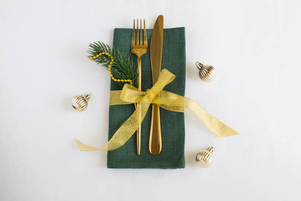 istock Christmas table setting with green napkin on the white tablecloth. Top view. Copy space. 1698677397