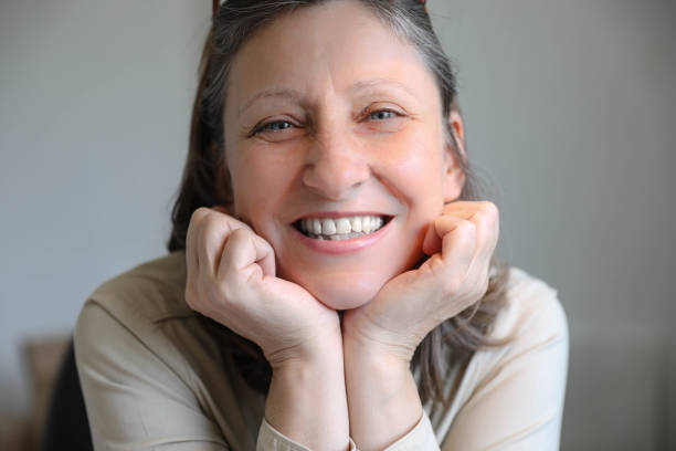 istock Happy mature businesswoman going through paperwork while working in office and looking at camera. 1698680839