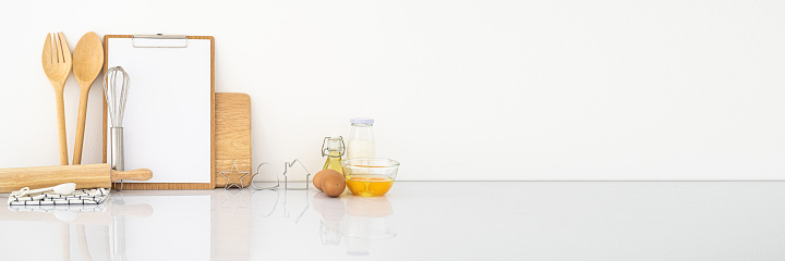 Banner with simple ingredients and kitchen tool on white table. White wall.Modern wooden kitchen table background. cooking at home Mockup.horizontal Panorama cover and header web Banner. Copy space.