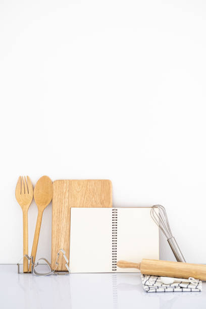 istock Vertical blank cook book  and wooden kitchen tool on white table and White background. Front view copy space 1698691000