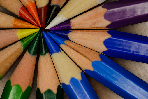Vibrant colored pencils arranged in a circle, tips meeting in the center, showcasing a spectrum in a macro shot