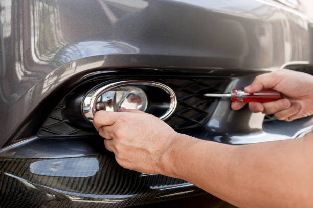 istock Car service and part maintenance concept, The Technician inserts the fog lamp into the front bumper of the car,Change the LED light bulb car basic service Safety inspection of automobile parts 1698729609