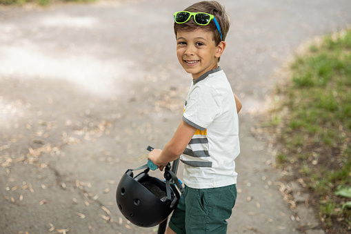 Close portrait of boy with his push scooter