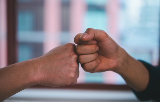 two man clashed fists of the other hand. Confrontation concept, business dealing agreement contract, success negotiation, greeting partner or friendship, offering helping hand teamwork cooperation