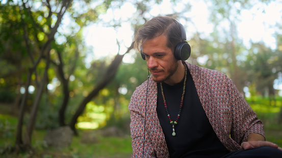 A man is focusing on making music in a public park.