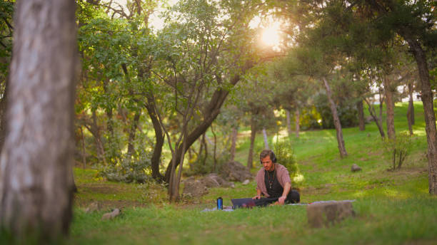 istock Man focusing on making music in public park 1698772748