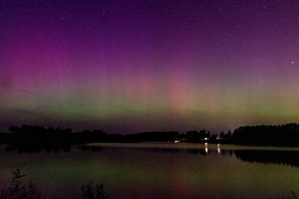 istock night image of a massive multi-colored green vibrant Aurora Borealis, Aurora Polaris also known as the northern lights in the night sky over a lake 1698774514
