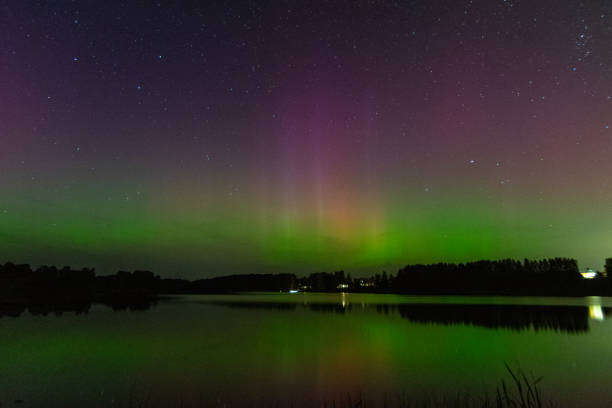 istock night image of a massive multi-colored green vibrant Aurora Borealis, Aurora Polaris also known as the northern lights in the night sky over a lake 1698774724