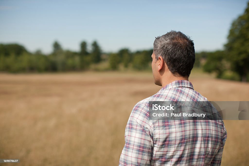 Man standing in rural field  Looking Up Stock Photo