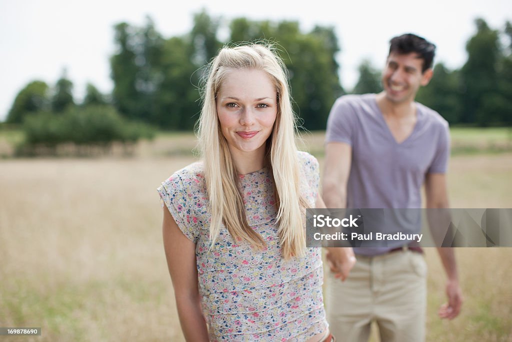 Retrato de Casal Jovem segurando as mãos na zona rural do campo - Foto de stock de Andar royalty-free