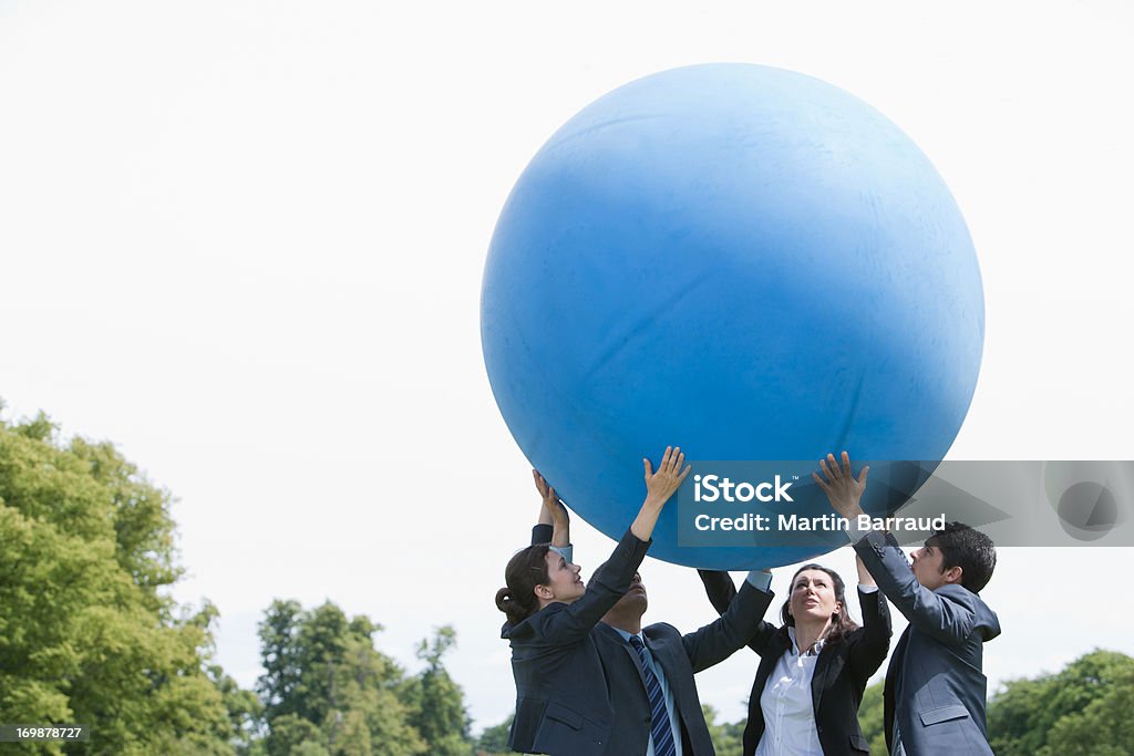 Деловой человек держит большой шар вместе - Стоковые фото Взаимодействие роялти-фри