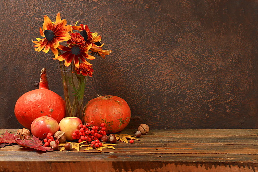 Autumn still life with apples, rowan berries, pumpkins, sunflower flowers on an old wooden table, background, Thanksgiving concept, rustic harvest, healthy natural food concept, banner for screen, advertising cafe, restaurant, selective focus