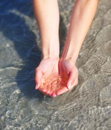 hands with sand at the sea